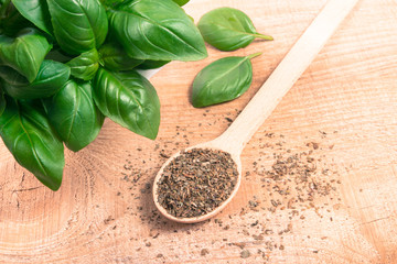Raw green basil and dried, on the wooden table.