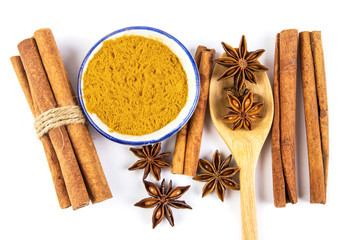 Close up the brown cinnamon stick and powder with star anise spice in wooden spoon isolated on white background