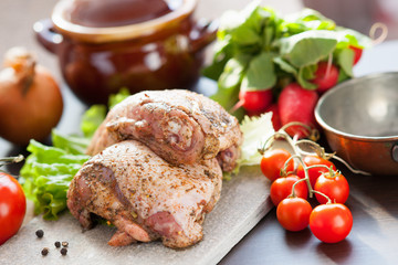 Marinated chicken meat, ceramic pot and vegetables 