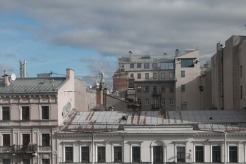 Obraz premium Piece of urban roofs against sky and clouds, Russia, Saint Petersburg.