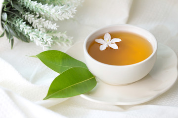 Close up organic tea in white cup with green leaf , Tea ceremony time concept