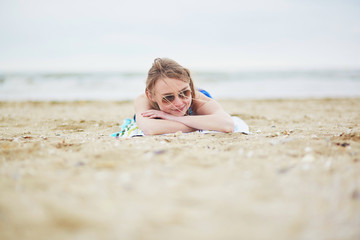 Woman relaxing and sunbathing on sand beach