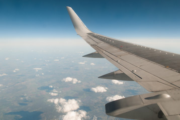 Fototapeta na wymiar The wing of the plane on blue sky,