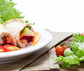fresh whole wheat bread wraps with vegetables and fruit on the plate , healthy and clean food concept
