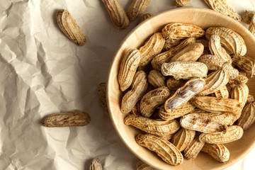 boiled peanuts in wooden cup on crumpled paper