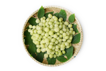 top view fresh Phyllanthus acidus or  star gooseberry with green leaves on bamboo basket background