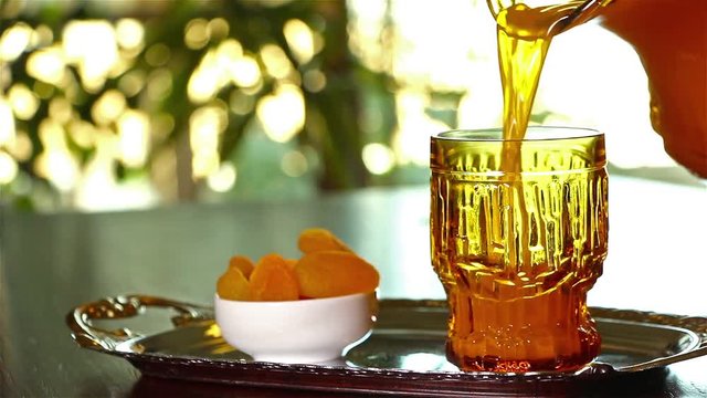 Man pouring Qamar El Din (Apricot Juice) into a glass , ready for happy breakfast in Ramadan