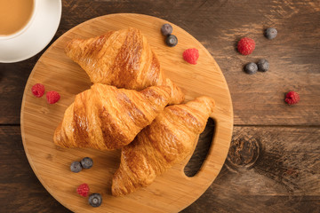 Fresh croissants with blueberries, raspberries, and latte