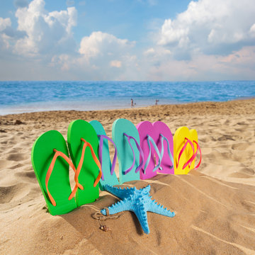 Summer beach fun - set of family sandals in beach sand