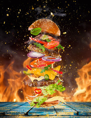 Big tasty burger with flying ingredients.
