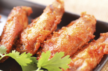 Close up Spicy Deep Fried Breaded Chicken Wings with Ranch and coriander on black plate