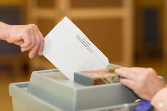 Stimmzettel in Wahlurne.