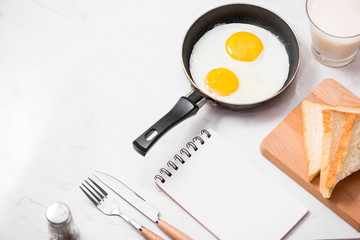 Top view of traditional healthy easy quick breakfast meal made of fried eggs served on a frying pan.