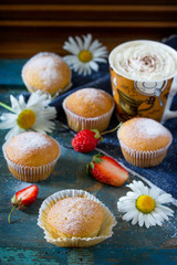 Delicious cake with strawberries on a blue antique wooden table.
