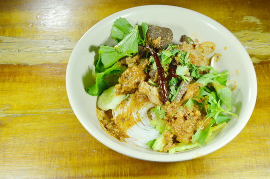 rice noodles dressing spicy minced pork and bone red cotton tree sauce with vegetable on bowl