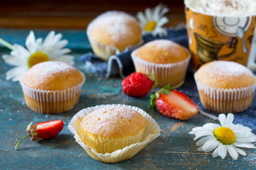 Delicious cake with strawberries on a blue antique wooden table.