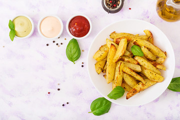 Ruddy Baked potato wedges with  herbs on a light background. Flat lay. Top view.
