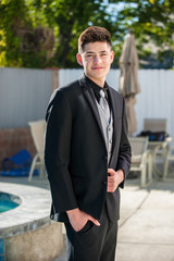 Handsome Mexican teen with hand in pocket of formal black suit in 3/4 view.  © motionshooter