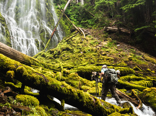 Photographer in Lush Waterfall
