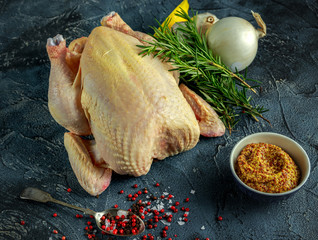 Whole Raw Chicken with ingredients for cooking. on stone background