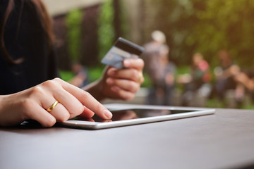 close up woman hand touch screen on tablet pad and holding credit card for shop online