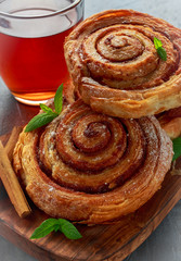Freshly Baked Traditional Sweet Cinnamon Rolls, Swirl with hot black Tea and mint