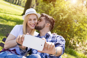 Flirting couple having fun and taking selfie on beautiful sunny day