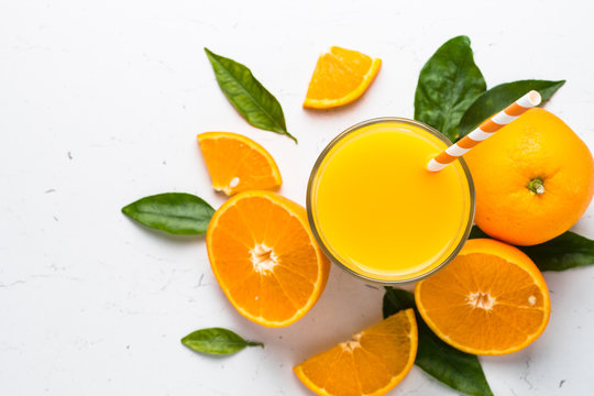 Orange juice in glass on white.