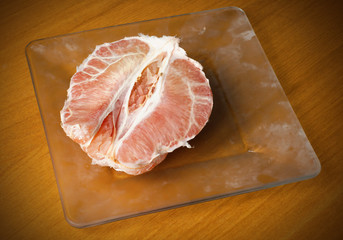 Half a pomelo on a glass plate