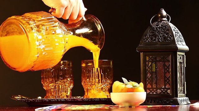 Woman pouring Qamar El Din (Apricot Juice) into a glass , ready for happy breakfast in Ramadan