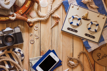 Striped slippers, camera, phone and maritime decorations, top view