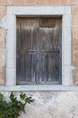 very old shutters in front of window in ancient greek building