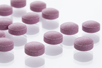 Obraz na płótnie Canvas 散らばった複数の紫色の錠剤