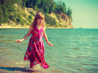 Toddler girl wearing dress playing in water