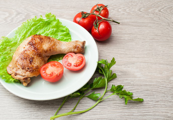 Fried chicken with vegetables on a wooden background. Place for text