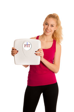 Happy young blond woman showing a scale as she has perfect shape and weight