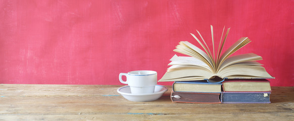 open book and cup of coffee on red background,free copy space