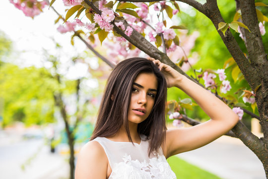 Girl with sakura tree flowers. Focus on face. Spring concept