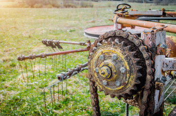 Old rusty species of part of agricultural machinery in rural areas. - obrazy, fototapety, plakaty