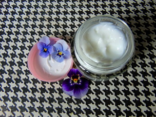 Obraz na płótnie Canvas Facial cream for good skin care with purple flowers