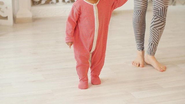 Mom teaches her son to walk. Mixed race baby