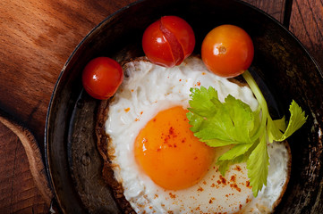 Toasted egg in a frying pan, sprinkled with hot pepper.