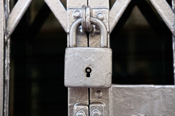 Old silver color metal lock on the gate.