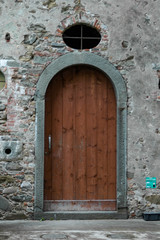 Arched wood door in stone wall
