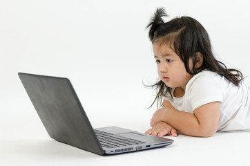 Asian child playing on computer laptop