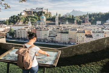 Fototapeta na wymiar Austria. Salzburg. The girl tourist on the observation deck at the old maps of the city with views of the Hohensalzburg fortress