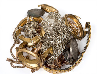 A scrap of precious metals. Old and broken jewelry, watches of gold and silver on a white background.