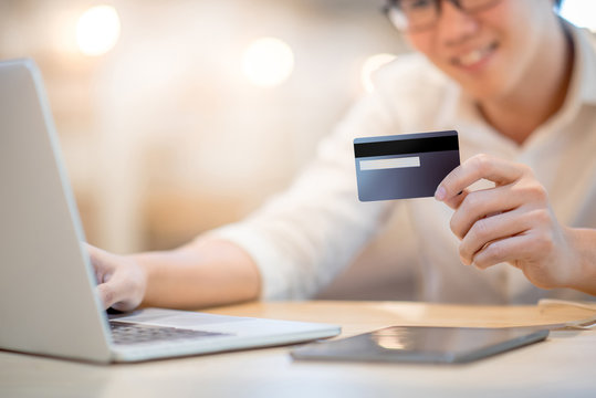 Man hand holding credit card, see the security code and using laptop computer for online shopping and online payment, modern lifestyle with digital transaction concepts