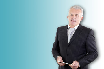 Smiling mature businessman working on digital tablet isolated on colored background