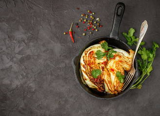 Baked organic cabbage with spices, cilantro and hot sauce. Selective focus. Copy space. Top view